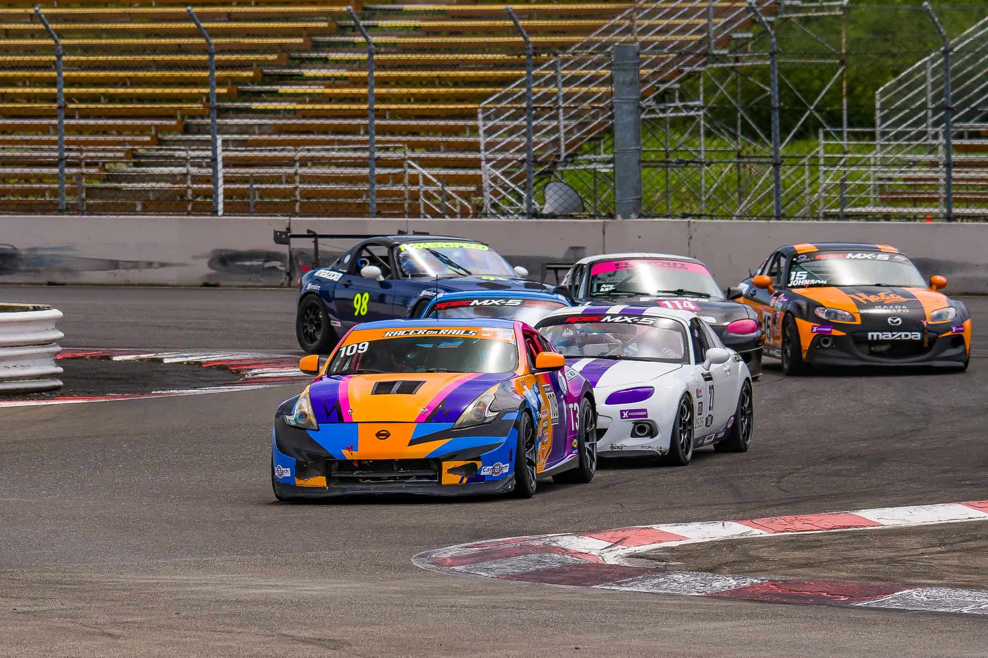 Racer on Rails Nissan 370Z leading a tight pack of race cars through the Portland International Raceway chicane during the SCCA Hoosier Super Tour.