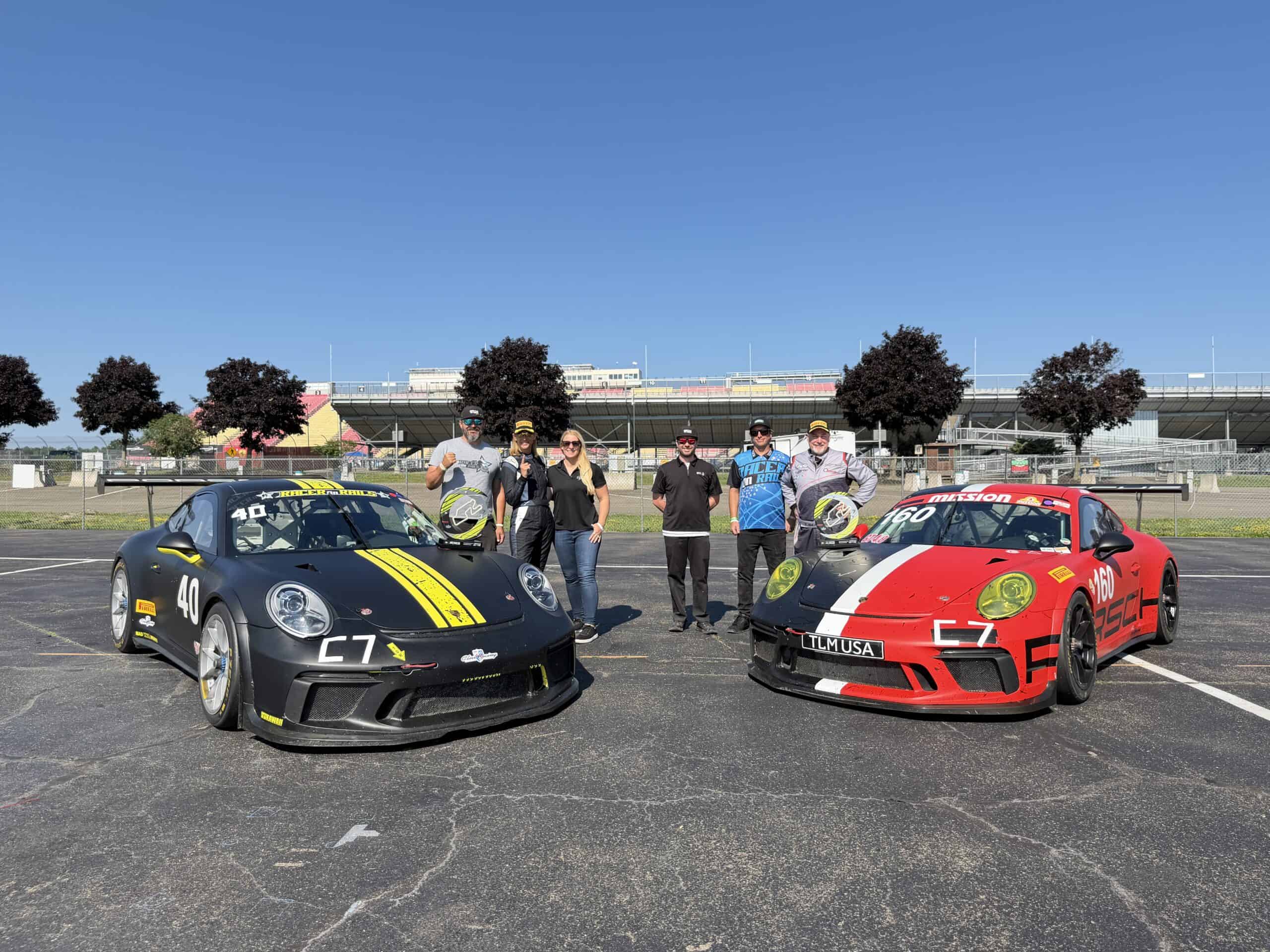 Racer on Rails team with Ann Doherty’s black Porsche race car, Thad Berger’s red Porsche and their podium trophies at Watkins Glen.